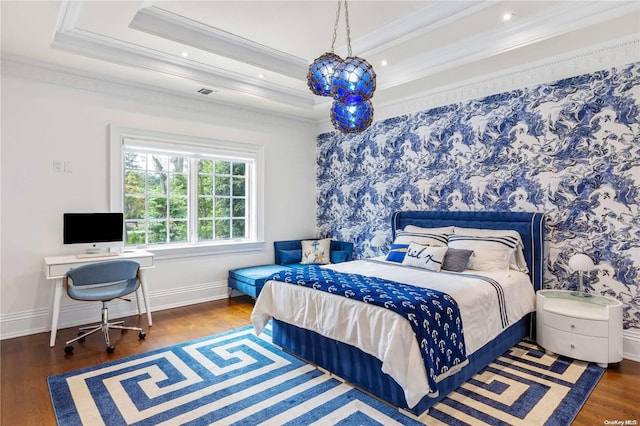 bedroom with dark hardwood / wood-style flooring, a tray ceiling, and ornamental molding