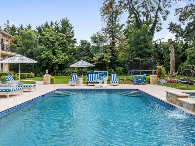 view of pool with a patio and a trampoline