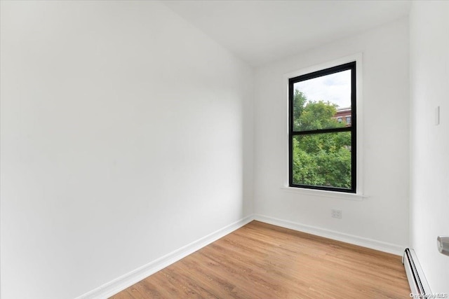 spare room with light hardwood / wood-style floors and a baseboard heating unit