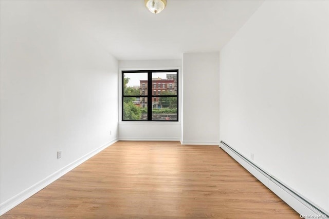 spare room featuring light hardwood / wood-style floors and a baseboard heating unit