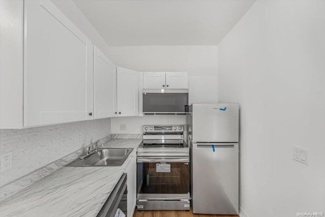 kitchen featuring white cabinetry, sink, light wood-type flooring, and appliances with stainless steel finishes