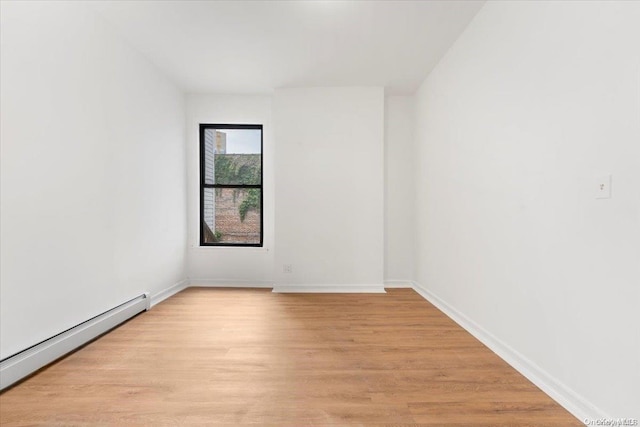 empty room featuring light hardwood / wood-style flooring and a baseboard heating unit