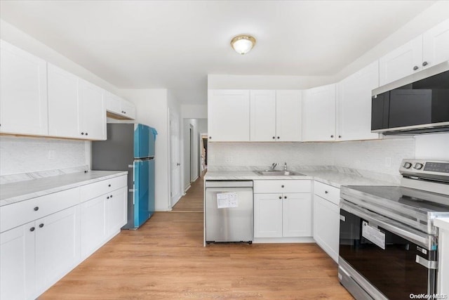 kitchen featuring sink, white cabinetry, stainless steel appliances, and light hardwood / wood-style flooring