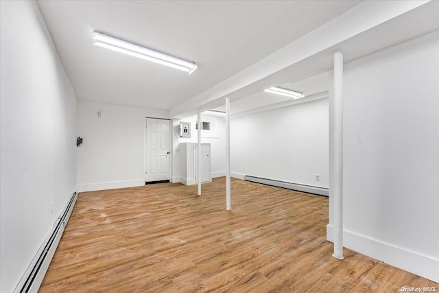 basement with hardwood / wood-style floors and a baseboard heating unit