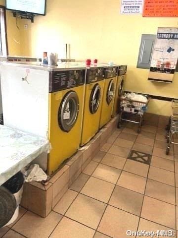 laundry room featuring light tile patterned flooring and washing machine and clothes dryer