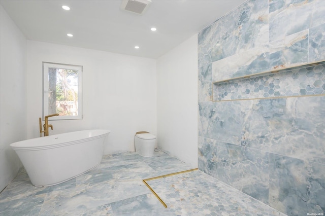 bathroom with toilet, tile walls, and a tub