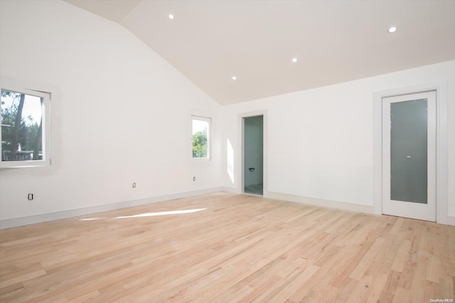 unfurnished room with plenty of natural light, high vaulted ceiling, and light hardwood / wood-style flooring