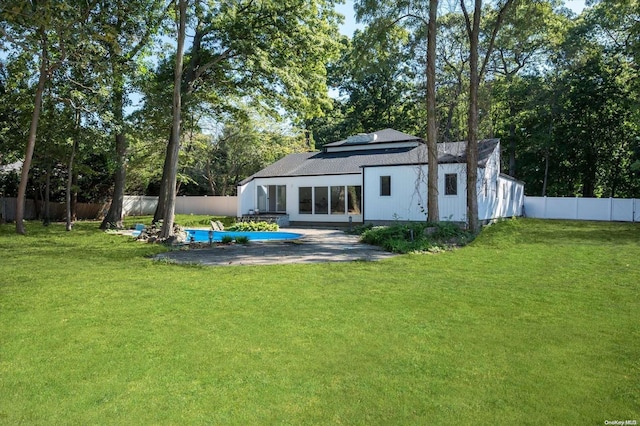 rear view of house with a yard and a patio area