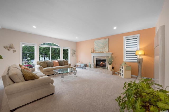 living room with a tile fireplace and carpet floors