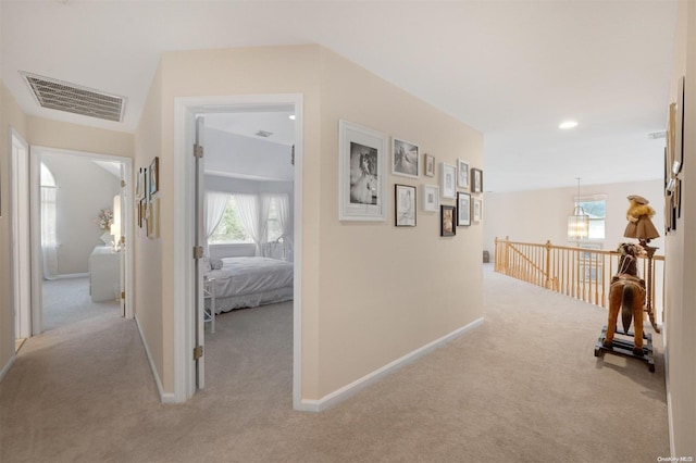 corridor featuring plenty of natural light and light carpet