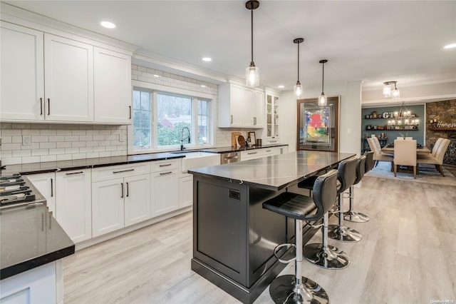 kitchen featuring white cabinets, pendant lighting, and backsplash