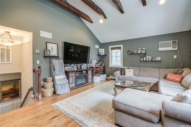 living room featuring beam ceiling, high vaulted ceiling, hardwood / wood-style flooring, and a wall unit AC