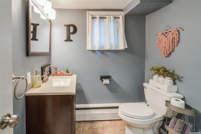 bathroom with tile patterned floors, baseboard heating, vanity, and toilet