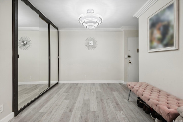 interior space featuring light hardwood / wood-style floors, a notable chandelier, and ornamental molding