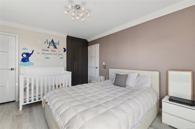 bedroom with light wood-type flooring, an inviting chandelier, and ornamental molding