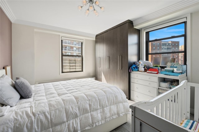 bedroom featuring multiple windows, crown molding, and a chandelier