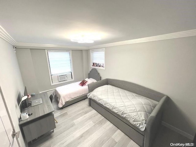 bedroom featuring light wood-type flooring and crown molding