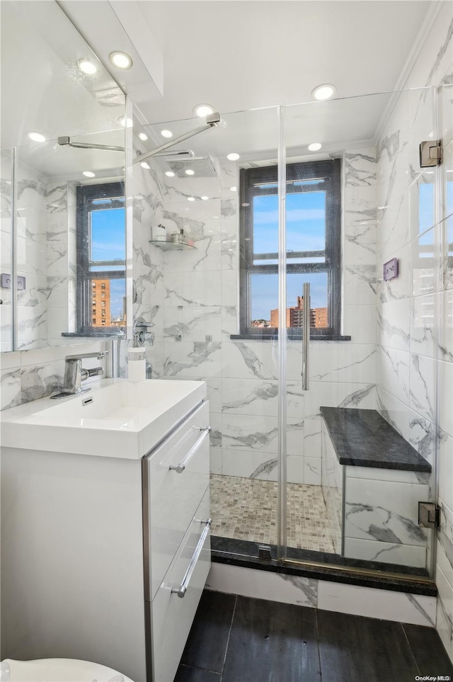 bathroom with vanity, walk in shower, crown molding, and tile walls