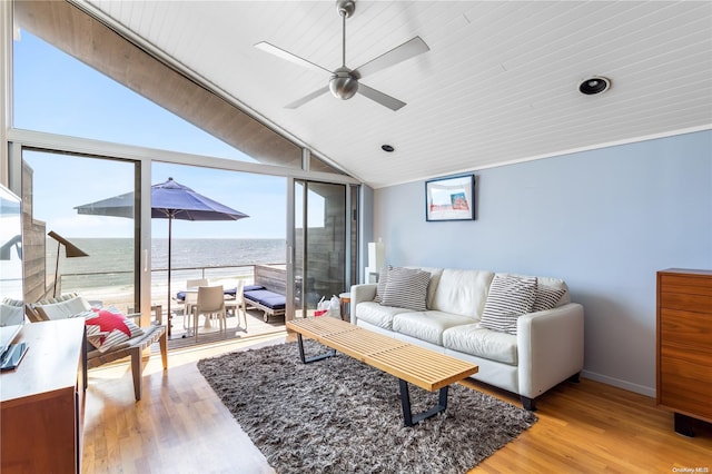 living room featuring lofted ceiling, a water view, and light wood-type flooring