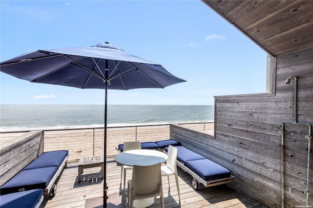 wooden terrace with a water view and a view of the beach