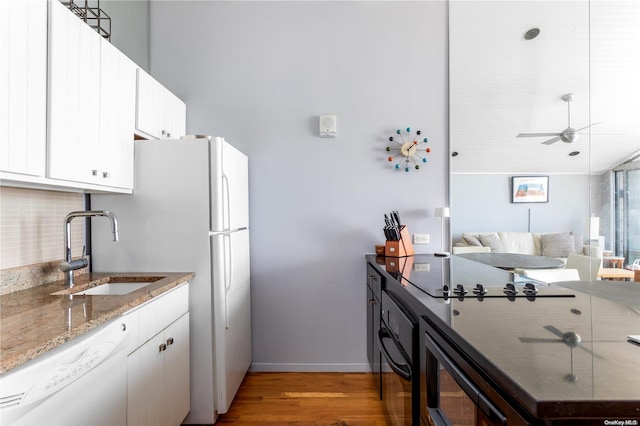 kitchen featuring white cabinetry, white appliances, sink, and light hardwood / wood-style flooring