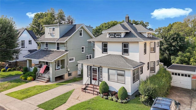 view of front of house with a front yard, an outdoor structure, and a garage