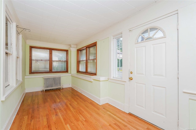 foyer entrance featuring radiator heating unit and light hardwood / wood-style floors