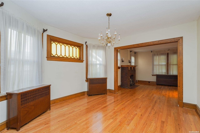 interior space with a fireplace, hardwood / wood-style flooring, and a notable chandelier