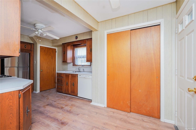 kitchen featuring stainless steel refrigerator, ceiling fan, sink, white dishwasher, and light hardwood / wood-style floors