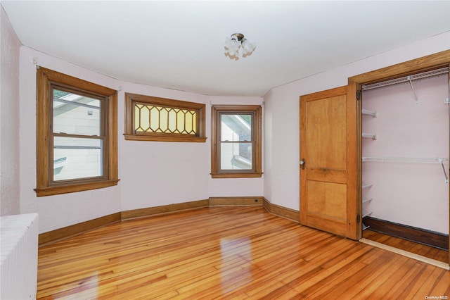 185 Utter Ave, Staten Island, NY 10314 - unfurnished bedroom featuring light wood-style floors, multiple windows, radiator, and baseboards