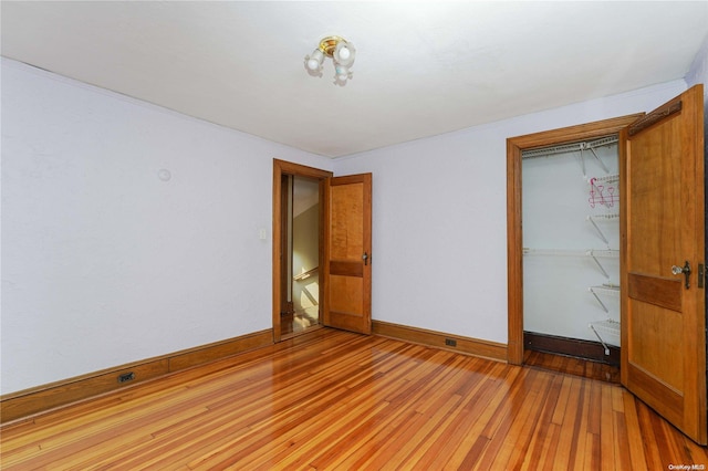 unfurnished bedroom with light wood-type flooring and a closet