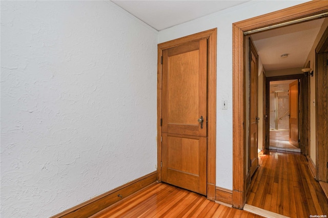 corridor with hardwood / wood-style flooring