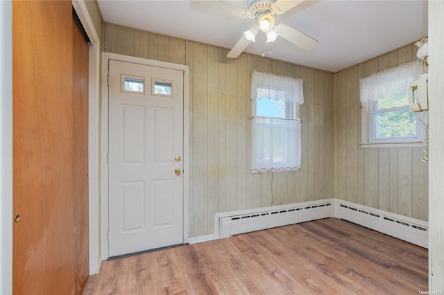 foyer featuring hardwood / wood-style floors, wood walls, and a wealth of natural light