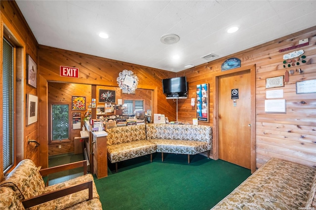 carpeted living room featuring wooden walls