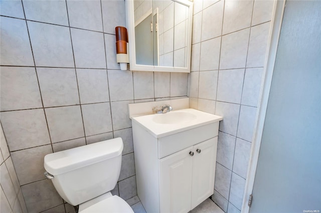 bathroom with vanity, tile walls, and toilet