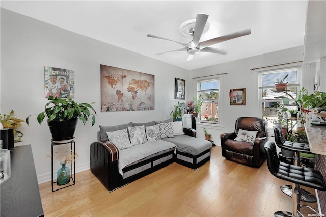 living room with ceiling fan and light hardwood / wood-style flooring