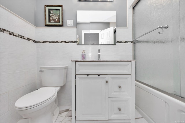 bathroom featuring vanity, toilet, and tile walls