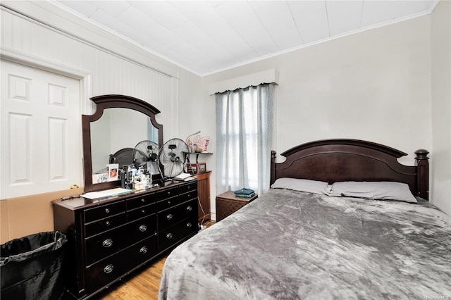 bedroom with crown molding and light wood-type flooring