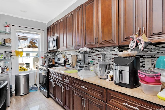 kitchen featuring light stone counters, ornamental molding, backsplash, and appliances with stainless steel finishes