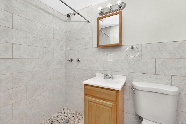 bathroom featuring vanity, toilet, and tile walls