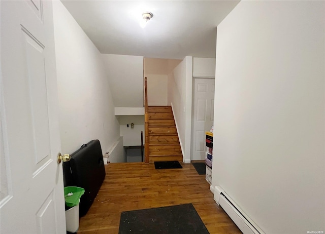 stairs featuring wood-type flooring and baseboard heating