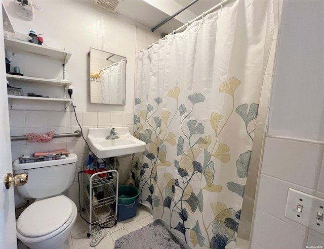 bathroom with tile patterned floors, sink, tile walls, toilet, and curtained shower