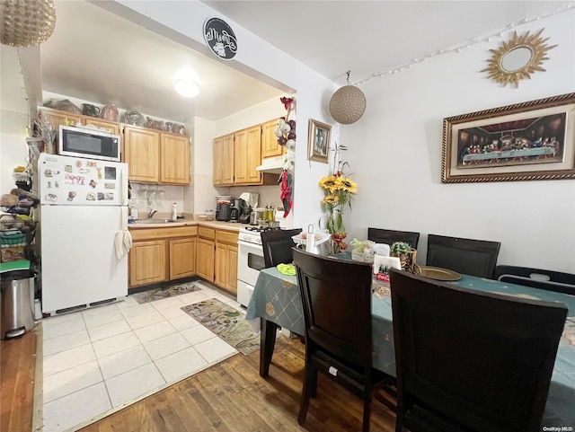 kitchen featuring white appliances, sink, light hardwood / wood-style flooring, light brown cabinetry, and tasteful backsplash