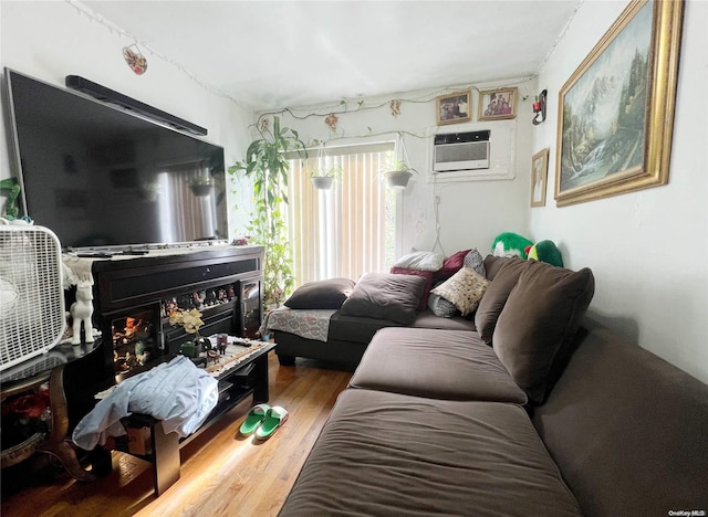 living room featuring hardwood / wood-style floors and an AC wall unit