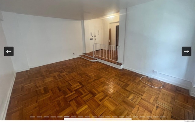 unfurnished room featuring dark parquet flooring