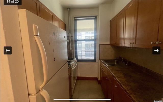 kitchen featuring sink, white fridge, and light tile patterned floors