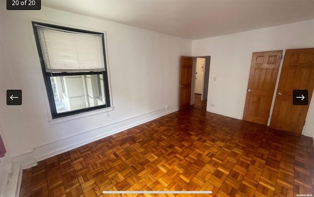 spare room with dark parquet flooring