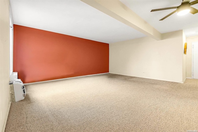 spare room with beam ceiling, ceiling fan, and carpet floors