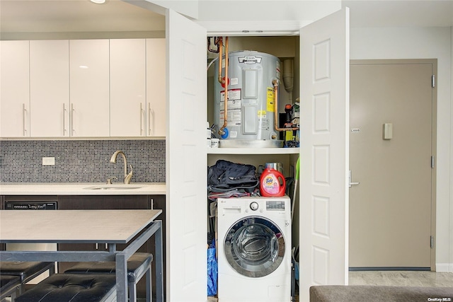 washroom with electric water heater, sink, light wood-type flooring, and washer / dryer