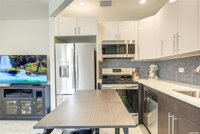 kitchen featuring sink, decorative backsplash, dark brown cabinets, white cabinets, and appliances with stainless steel finishes